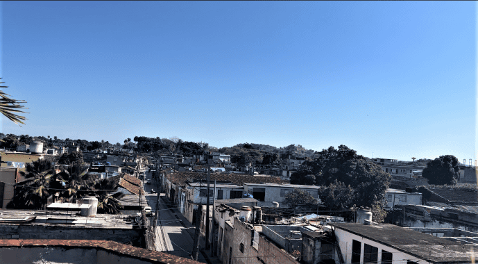 Photo taken from a rooftop terrace in Santa Clara, on a bright summer day with blue skies, and a sea of rugged rooftops along the city streets. 