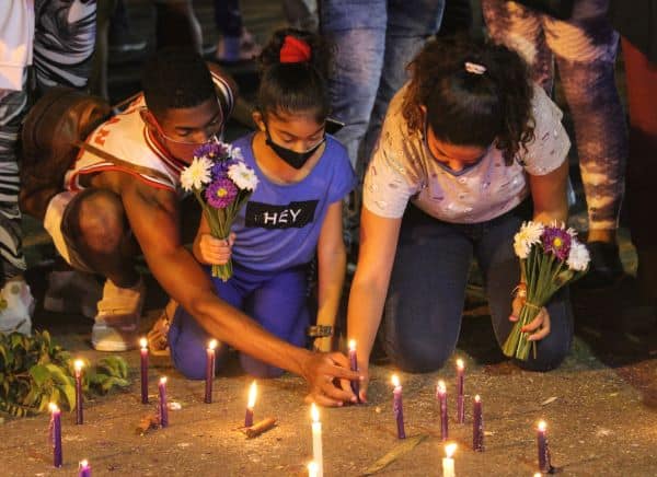 A Santeria ceremony where people light candles and offer flowers 