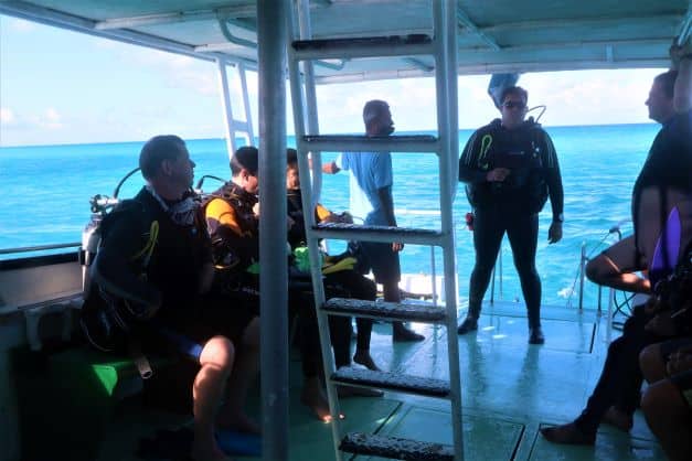 The dive group seated at the aft of the boat waiting for the all clear to exit the blue water outside. 