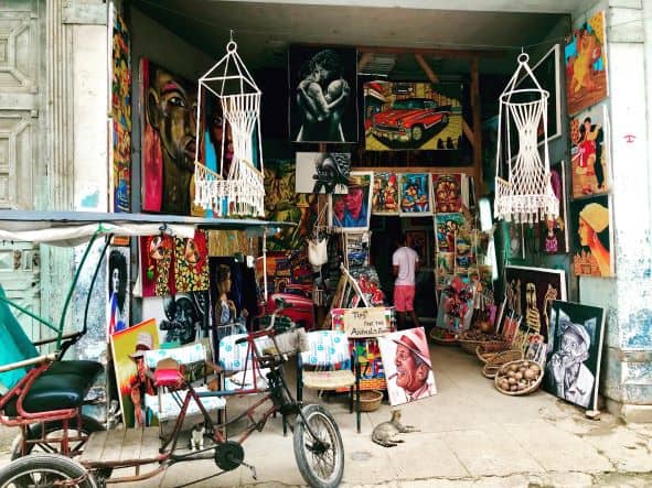 Tourist shop in Havana with lots of artwork, including typical colorful Cuban paintings