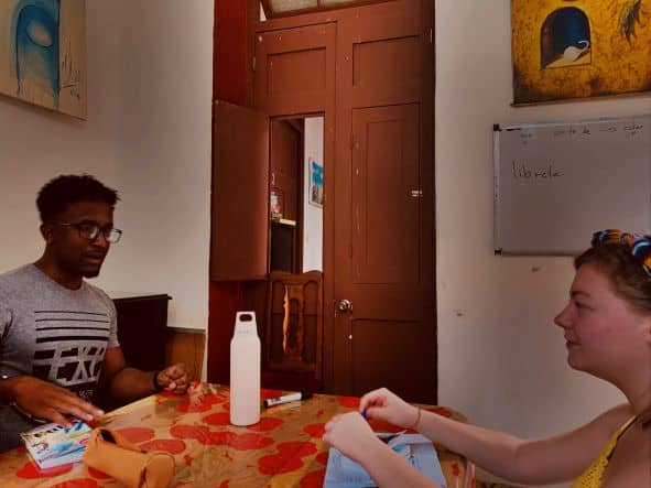 Spanish class in Old Havana, teacher and student around the table studying and speaking Spanish. 