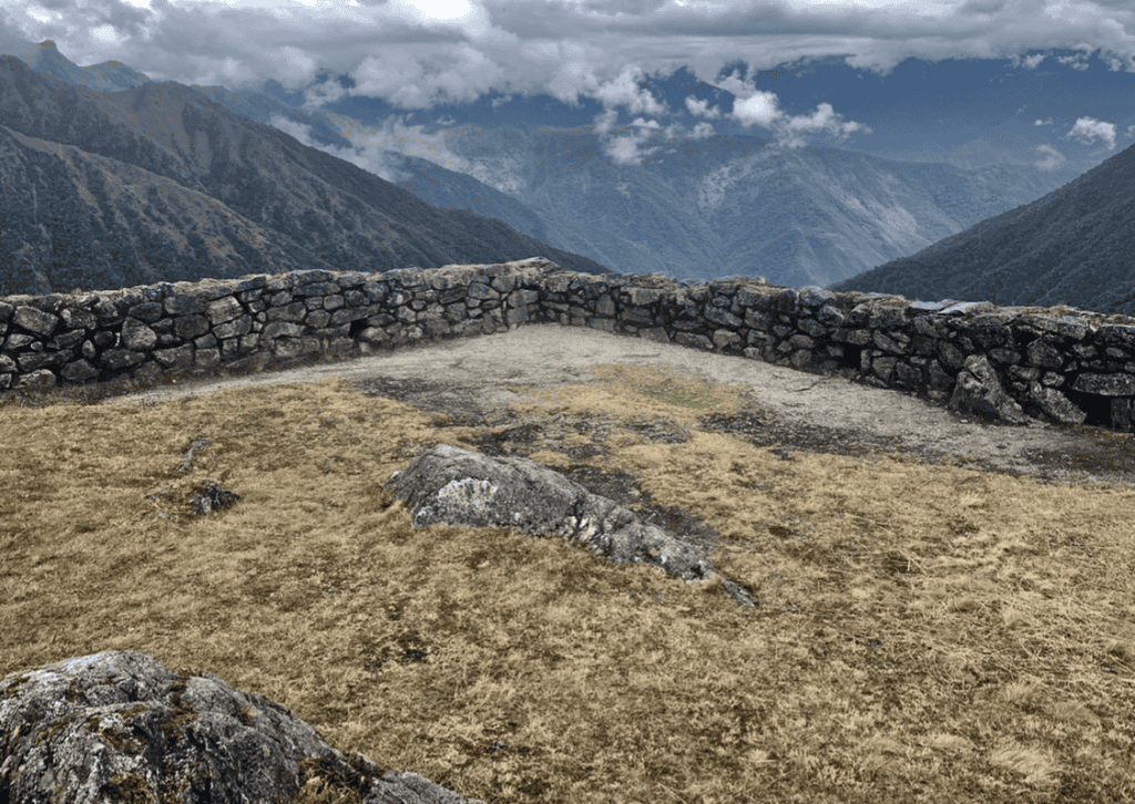 Stone structure on the Inca Trail shaped like a terrace, with infinite views covered by a ceiling of white clouds