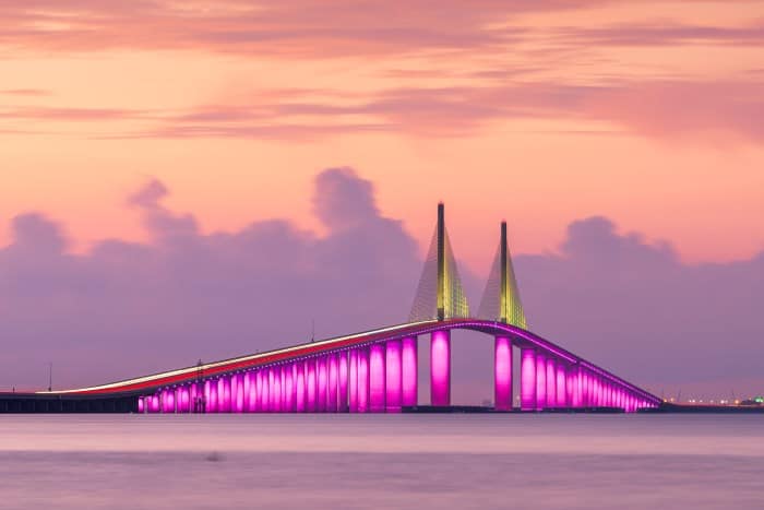St Petersburg Florida Bridge lit at night in yellow and purple 