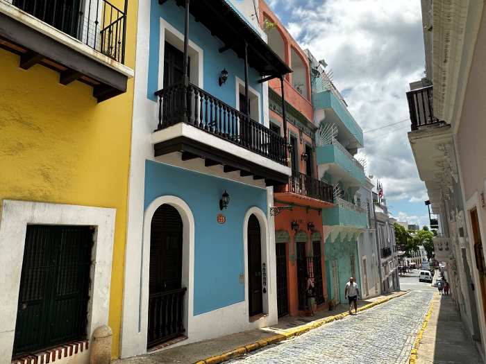 Narrow cobblestoned streets of San Juan surrounded by two storey colorful brick houses with small balconies