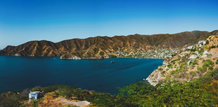 The charming Taganga Bay outside Santa Maria Colombia. The dark blue water is beautiful in contrast to the green hills around the small town. 