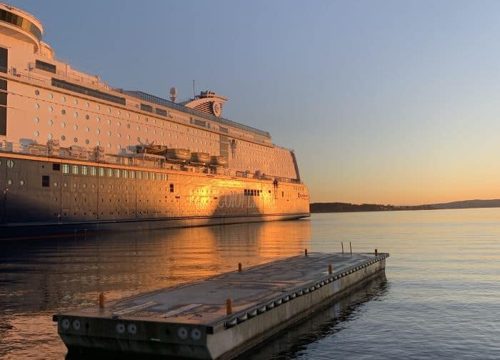 The Oslo Ferry port with a white large ferry glowing in the light from the setting sun on the water
