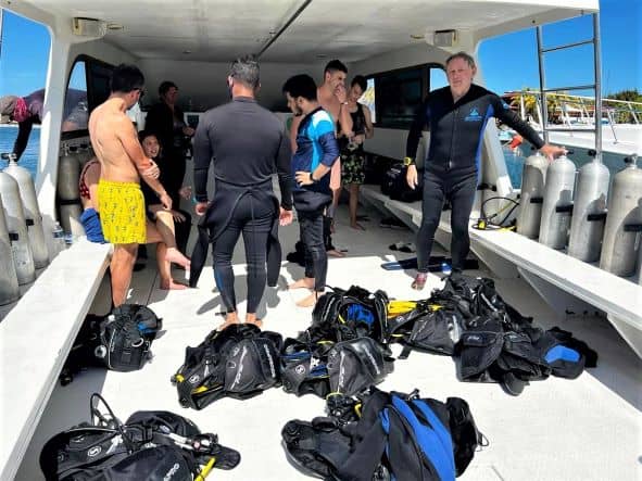 Divers on the white boat getting ready, with the gear sorted in bundles on the deck. 