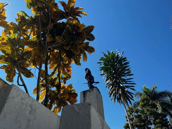 Photo from below of the Che Guevara statue in relieff to the deap blue sky on top of a white pidestall