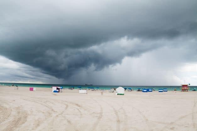 The white sands on Miami Beach on a cloudy day, where darker clouds and stormy weather are approaching from the horizon