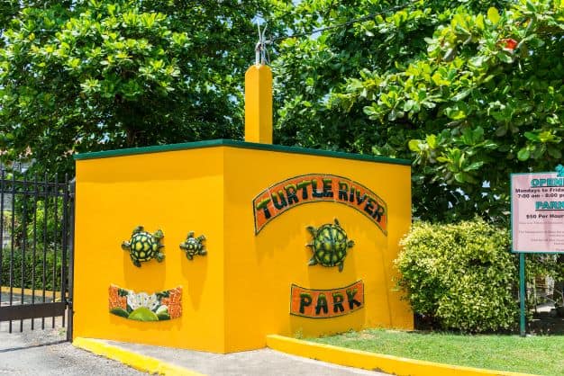 The entrance to Turtle River Park with a bright yellow welcome structure beside the gate telling you welcome!