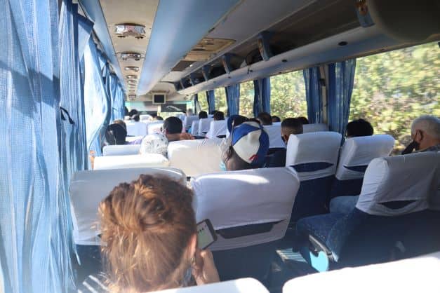 On the road with Viazul bus in Cuba, a comfortable bus service with soft blue and white seats on a sunny day. 