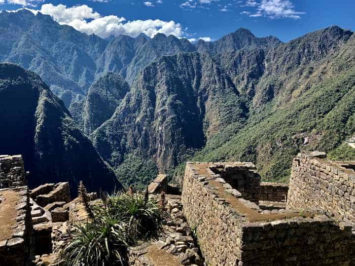 Views from Machu Picchu ruins over infinite mountains on a bright sunny day