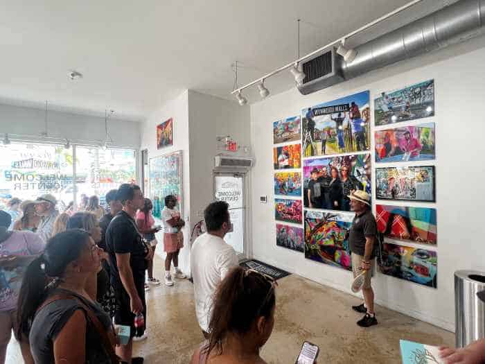 Wynwood Walls art center entrance area, a guide is speaking to a group about the paintings in the entrance area