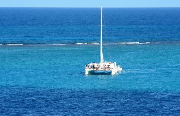 Catamaran Cruise; a white catamaran on the deep blue sea on a warm sunny summer day