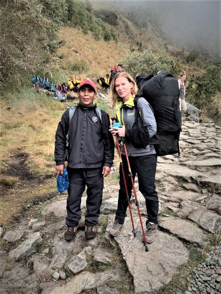 Photo of me and "my" sherpa, after the participant sherpa challenge, where I won! Still wearing the huge black backpack that the sherpa normally carry, smiling next to him before he gets it back. 