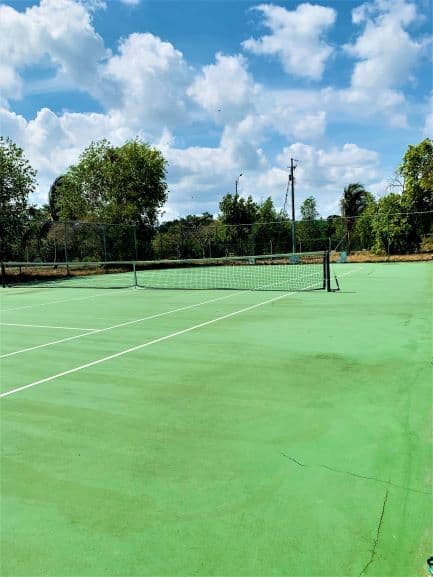 Tennis court with green floors and the net in the middle in Hotel Memories Miramar in Havana, Cuba. 