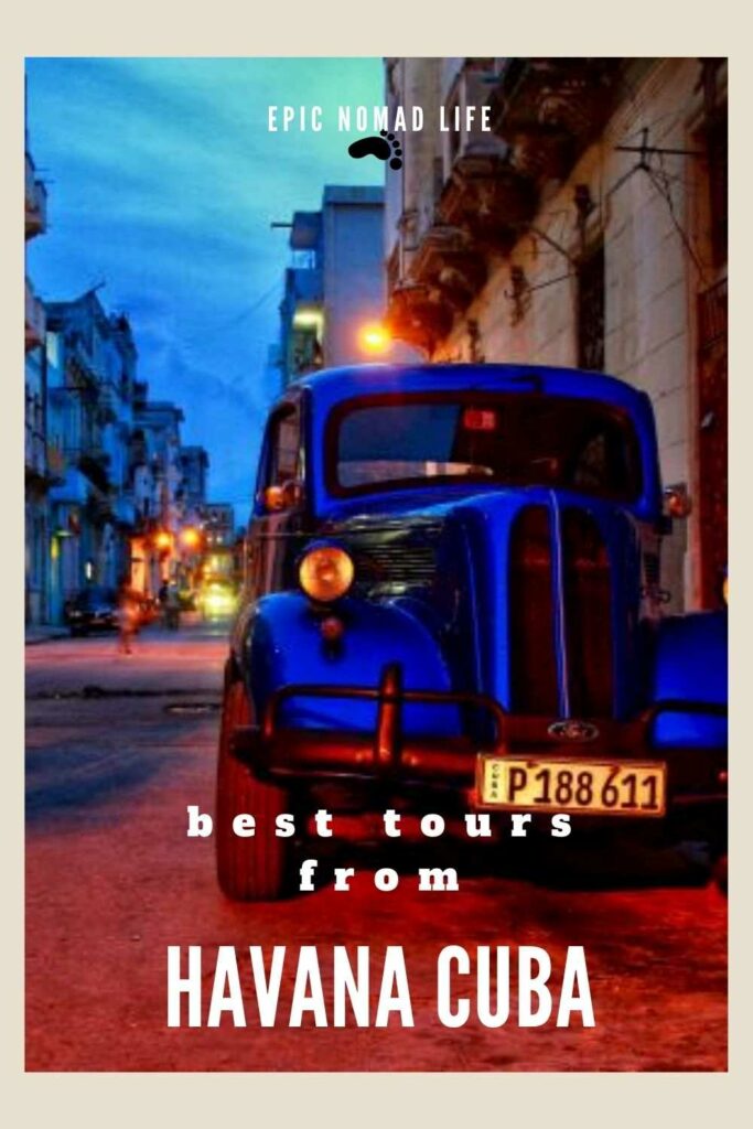 The best tours from Havana Cuba! Photo from Havana in the night, with an old Classic American car in a night street with deep blue skies above the narrow road with classic colonial houses on each side. 