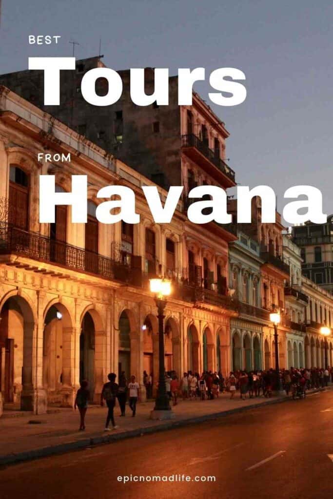 Classic colonial architecture in Havana in the evening, with lights from the street lamps, archways in the elegant colorful houses, and a dark night sky above. 