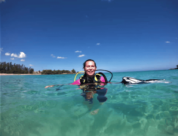 Me smiling in the crystal clear water outside Havana, Cuba, ready to go scuba diving with all the kit on, on a sunny summer day with blue skies above