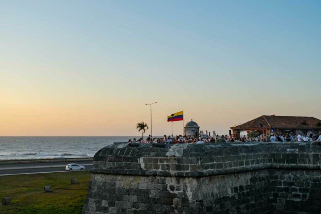 San Felipe Fortress in Cartagena in sunset, full of people enjoying the beautiful view of the glowing sun over the sea