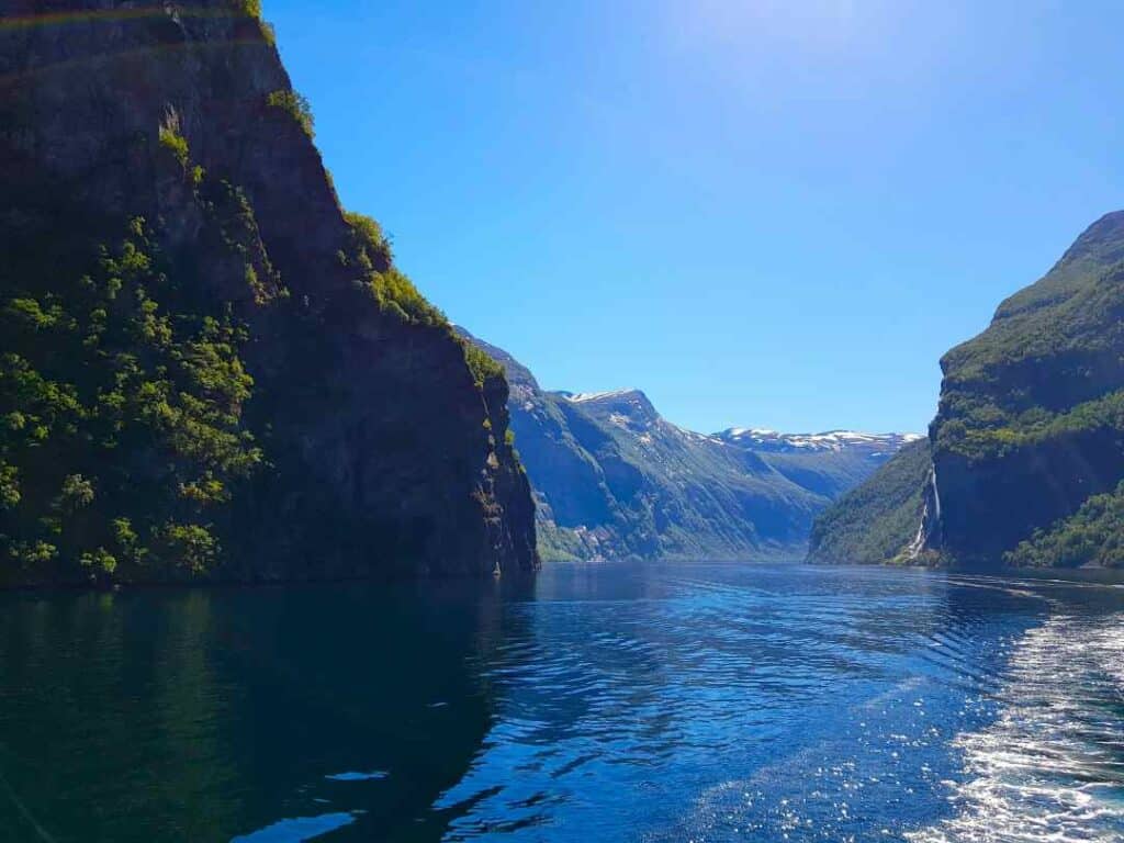 From a boat trip on a narrow fjord surrounded by steep mountains under a deep blue sky in the summer