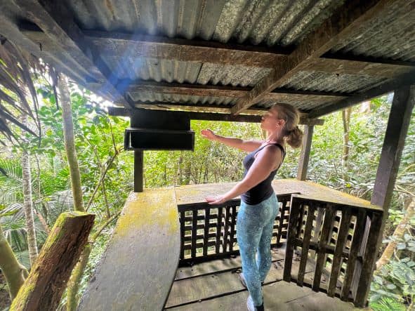 Lady standing on Fidel Castros old wooden balcony in Commandancia de la Plata in Sierra Nevada in the middle of the green jungle