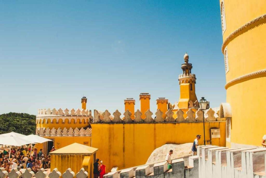 a yellow old fortress structure with walls and towers under a blue sky