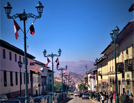 Is Cusco safe? A photo from the main street on a sunny day with blue skies and mountains far in the background