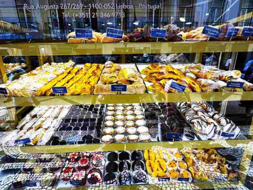 A display window with a myriad of different sweet pastries on trays