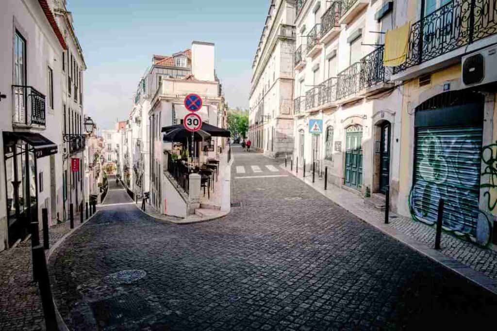 Twisting and turning hilly cobblestoned streets in a European old city surrounded by classical colonial houses on a sunny summer day