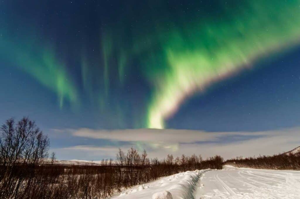 Norway in winter northern lights in the mountains over a white snowy plain