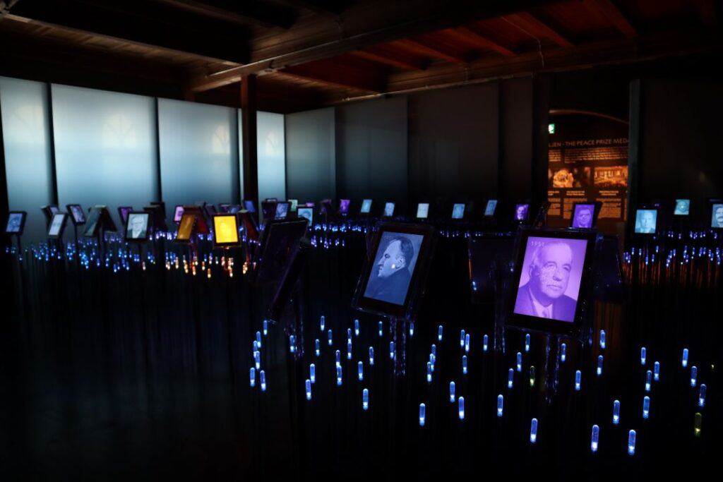 A sea of small lights in a dark room, with photos of important people around the sea of lights in the Peace Center in Oslo Norway