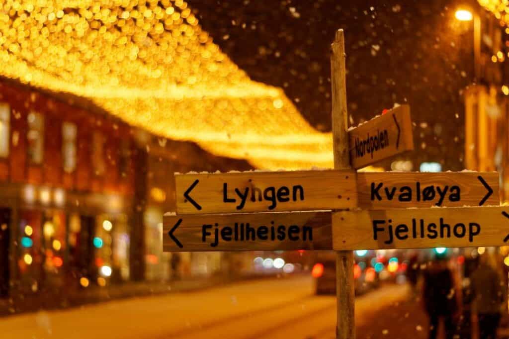 A wooden street sign to various sights in an arctic town during winter