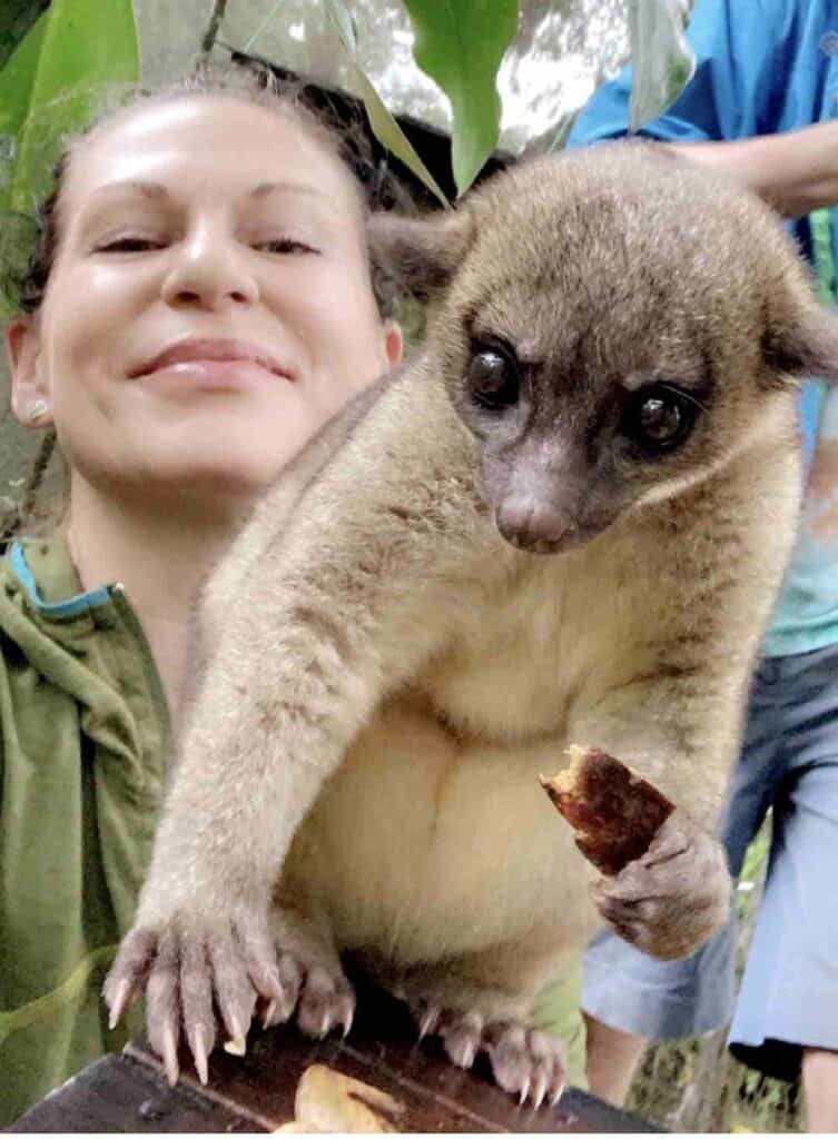 Woman smiling with a monkey for itinerary service